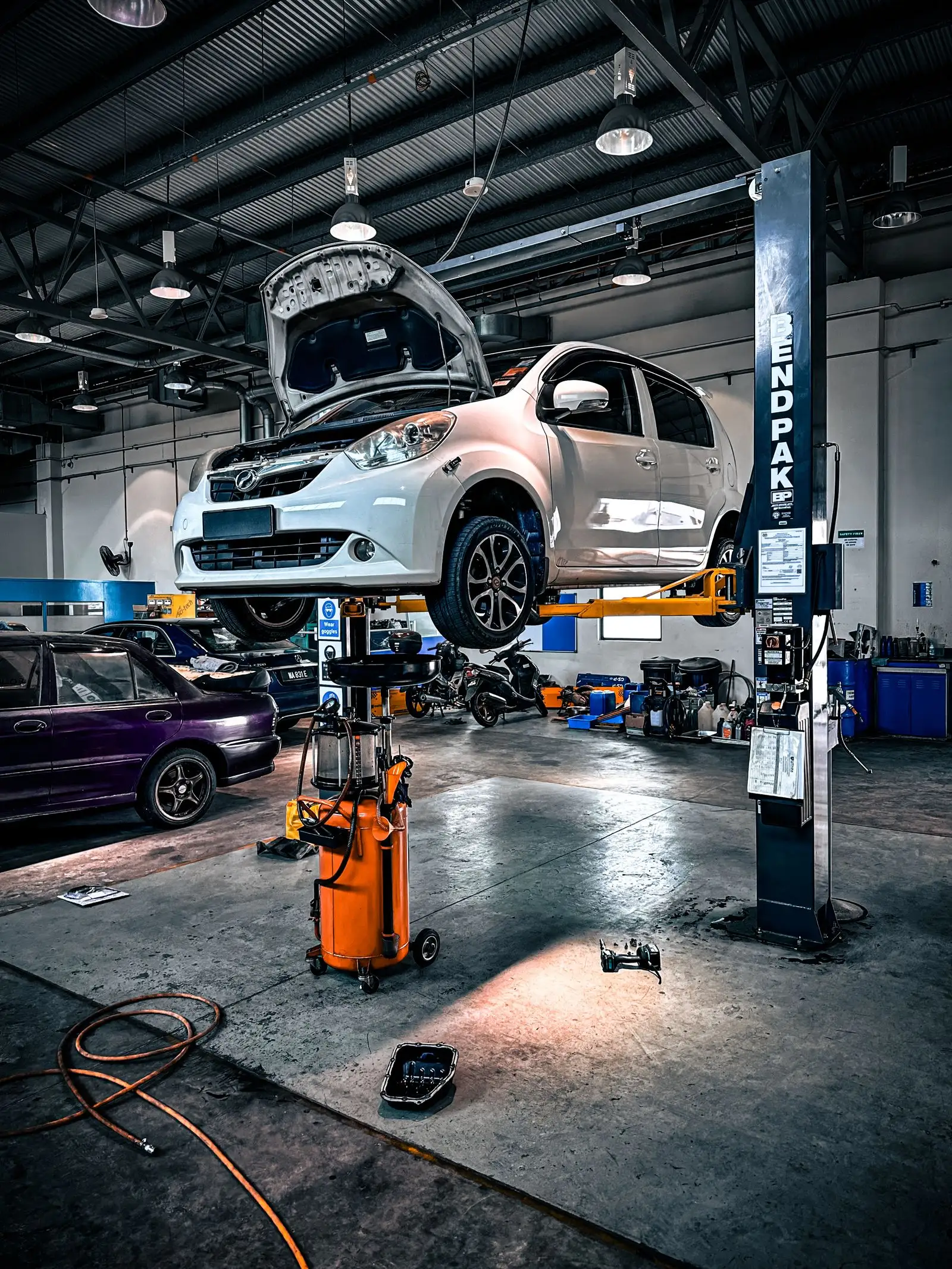 Auto shop service bay with a car on a lift, West Georgia