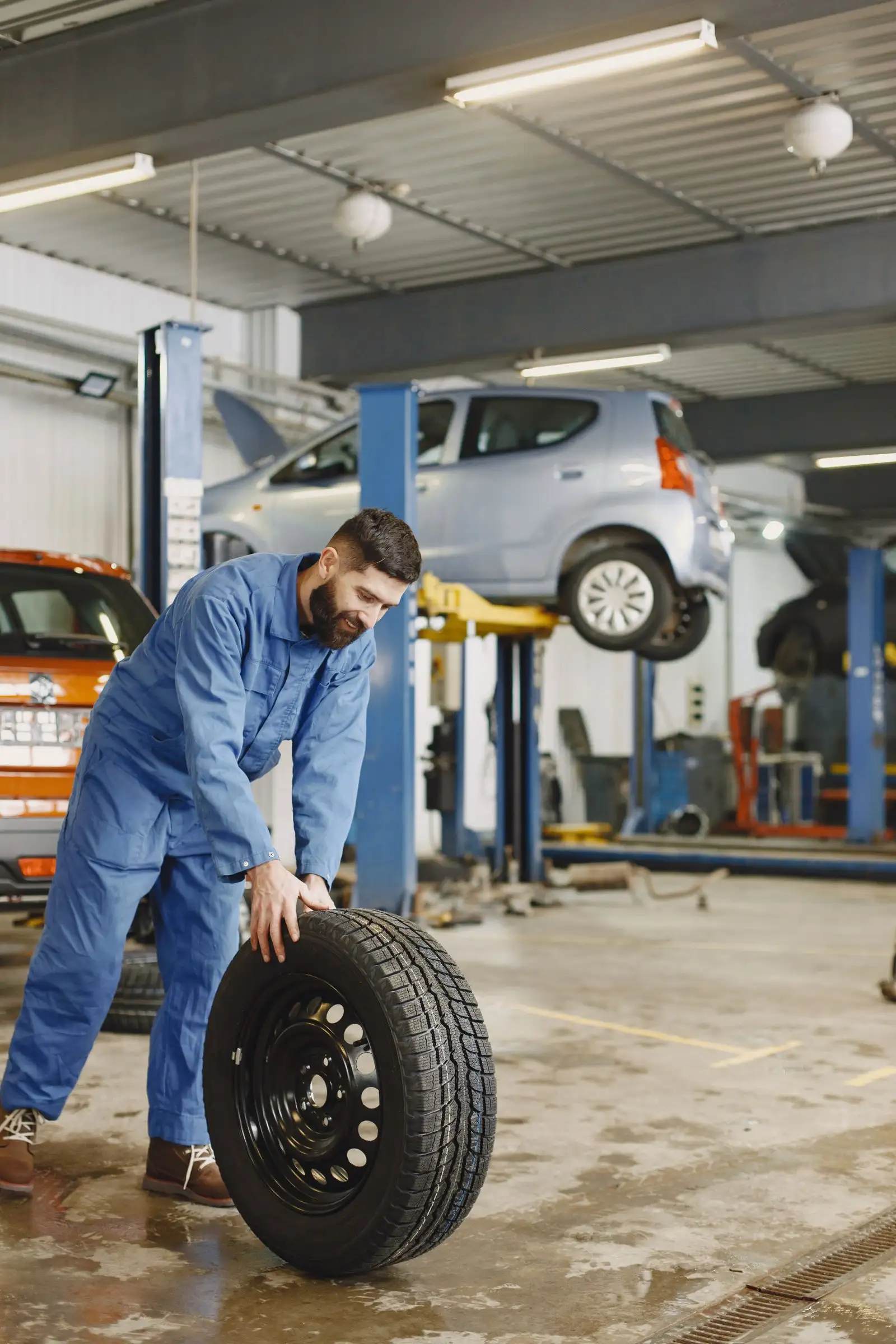 Mechanic working under a car on a lift in a West Georgia tire shop